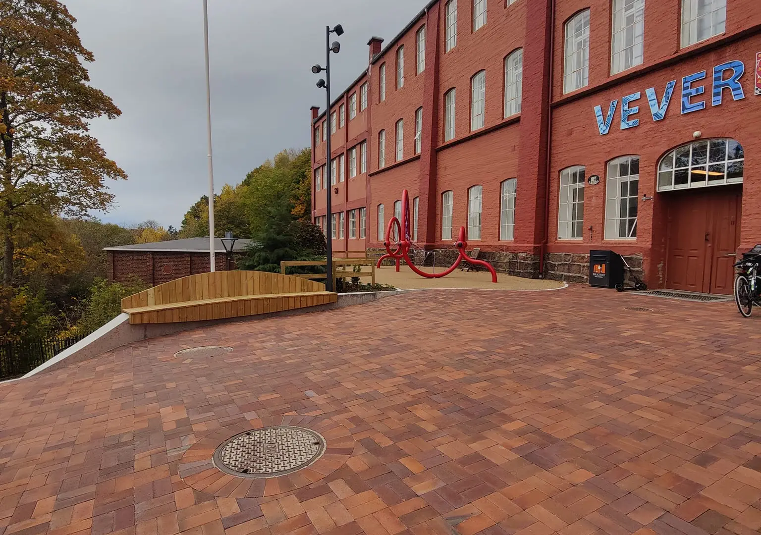 Støpte sittebenker med treseter på torget foran Veveriet i Ålgård