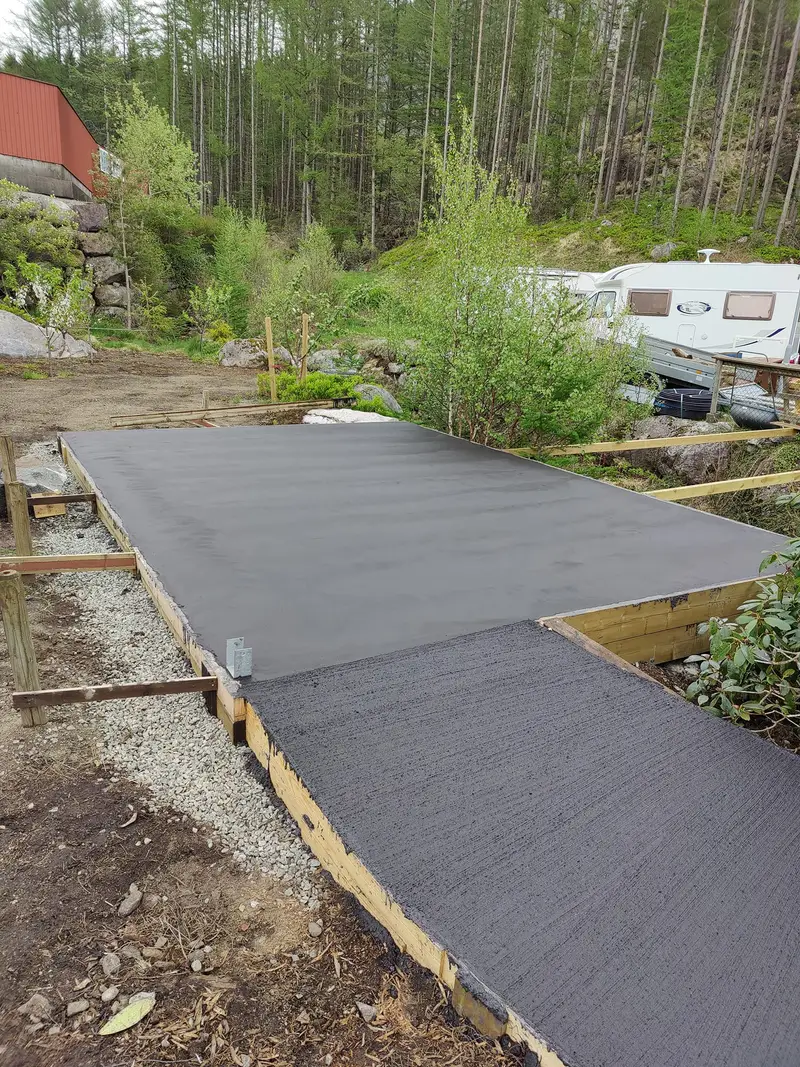 Svart betongplate med stålglattet flate og kostet gangvei, i forskaling
