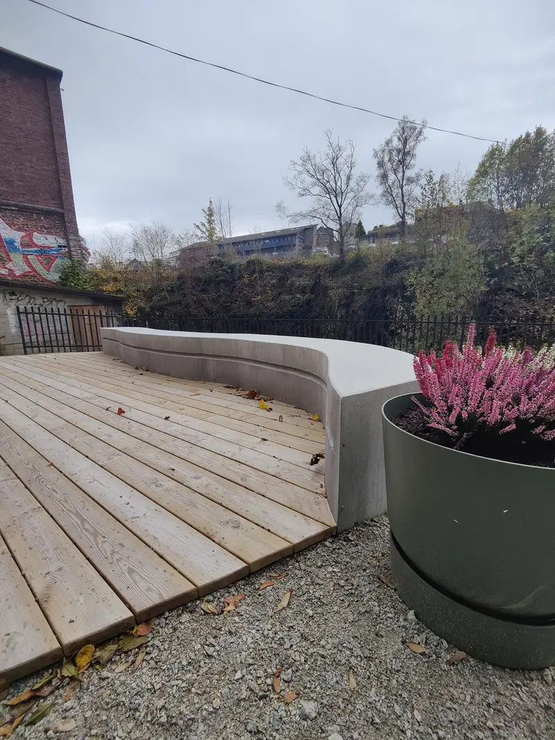Treterrasse inntil buet betongbenk og blomsterkrukke