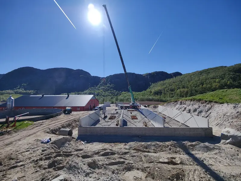 Kran setter opp veggelementer til plansiloen i solskinn