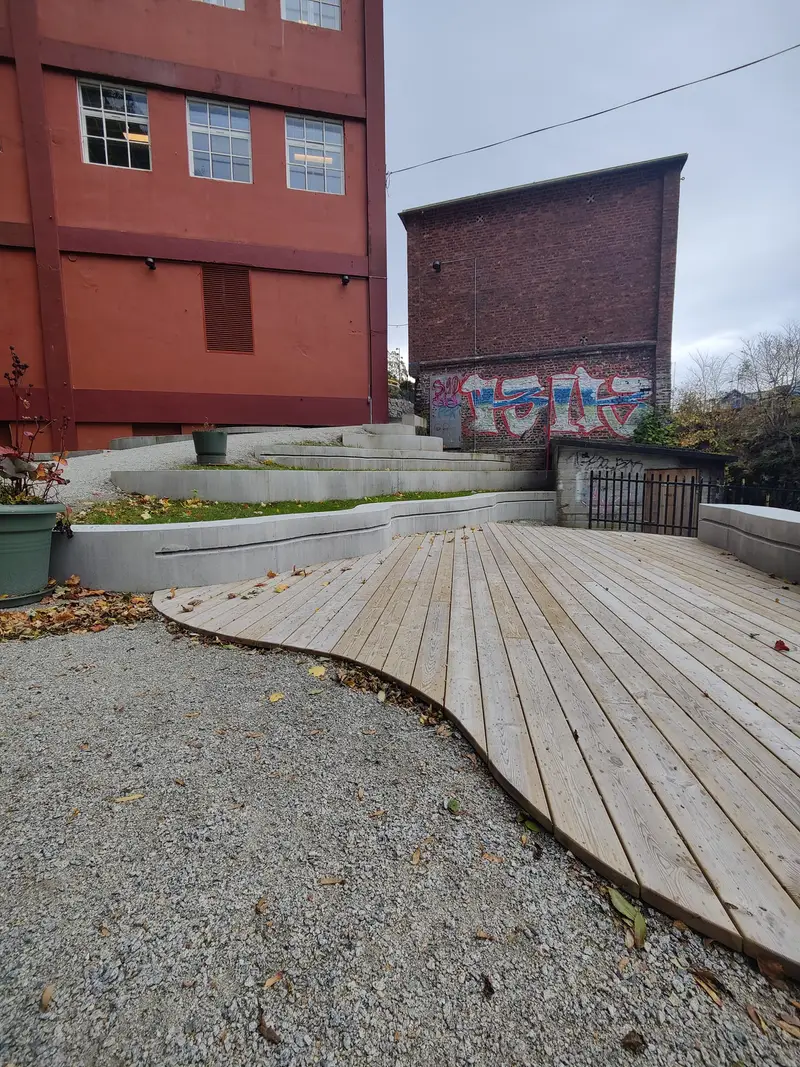 Bølgeformet treterrasse og betongkanter i flere nivåer