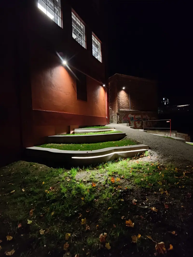 Belyste betongkanter med gress om kvelden
